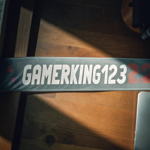 Gaming promotional banner with username 'GamerKing123'. Dark red background with white text. Simple design.