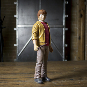 Highly detailed figurine of Ron Weasley from Harry Potter series. Standing pose, holding a wand, realistic features, placed on a plain black background