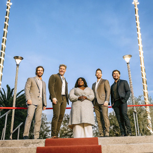 Premiere of 'Spirited', Ryan Reynolds, Will Ferrell, Octavia Spencer, Jamie Erlicht, Zack Van Amburg standing on red carpet. Bold, vibrant backdrop.