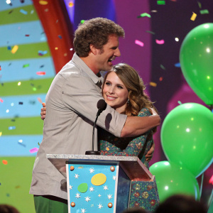Will Ferrell and Jon Heder hug at Nickelodeon Kids' Choice Awards. Emma Roberts stands by podium, surrounded by colorful confetti and green balloons.