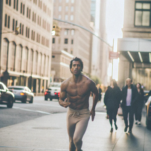 Francisco Lindor, star player for the Mets, running on a bustling city street, shirtless, with a determined look.