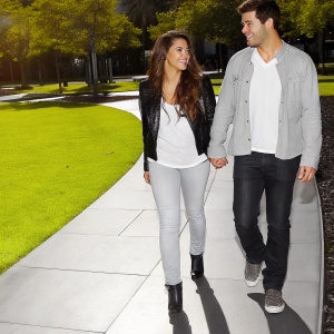 Shakira and Tonino Mebarak, dressed in casual outfits, walking through a brightly lit park.