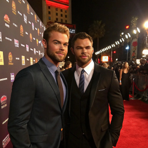Chris Witaske and Kellan Lutz attending premiere event. Red carpet ambiance, logo-filled backdrop.