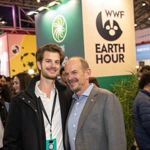 Andrew Garfield and Andy Ridley at a green energy conference, posing for photos with WWF and Earth Hour logos in the background.