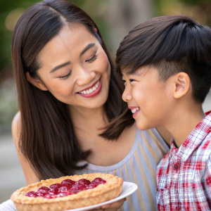 Cherry Pie Picache, a young Filipina woman, with a smiling Asian boy. The photo has a blurred background, emphasizing their warm expressions.