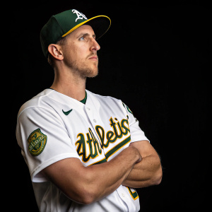 Stephen Piscotty, in white Oakland Athletics jersey, poses for a portrait. Solid black background