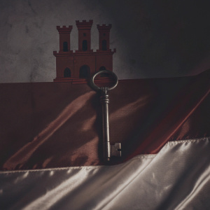 The flag of Gibraltar features a white background with a red castle and key emblem. The castle sits atop the key, both centered on the flag.