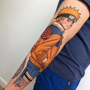 Large forearm tattoo of Naruto Uzumaki from the anime series. The tattoo includes vibrant colors and intricate details.