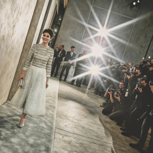Audrey Tautou, elegant and smiling, at Paris Fashion Week. Surrounded by flashing cameras and photographers.