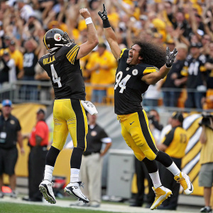 Ben Roethlisberger and Troy Polamalu at a post-game celebration. Players are cheering and jumping in the air. Crowd in background