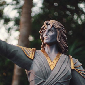 3D model of Adam Warlock. Gray statue with gold highlights. Expressive face and intricate hair design.