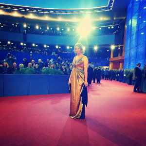 Franziska Weisz, in a stunning golden dress, at the Berlinale Film Festival. Crowded auditorium, bright spotlights