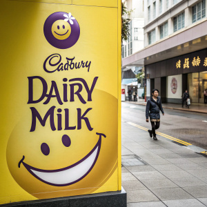 Cadbury Dairy Milk ad featuring a vibrant yellow background, a grinning yellow smiley face, modern font for brand name, and traditional chinese characters at bottom.