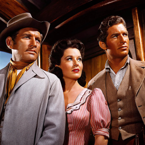 Promotional shot for the film 'Tortilla Flat', featuring Spencer Tracy, Hedy Lamarr, and John Garfield. Tracy positioned left, Lamarr centered, and Garfield on the right. They wear period-appropriate outfits. The background is an indoor setting with a rustic wooden texture, exuding a vintage charm.