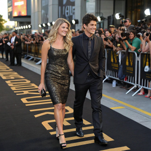 Lauren Collins and Adamo Ruggiero attending the 'Paradise City: Degrassi Goes Hollywood' premiere. Black and gold carpet with flashing cameras and fans.