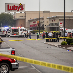 Outside Luby's Cafeteria, chaotic scene with emergency vehicles and caution tape. Documentary-style photograph capturing the aftermath of an event.