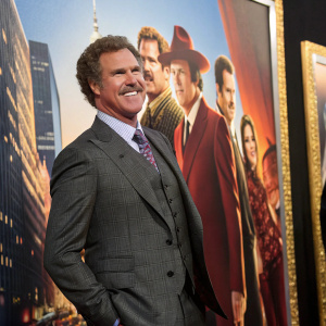 Will Ferrell in a stylish grey suit, smiling warmly in front of an elaborate backdrop featuring his co-stars from Anchorman 2: The Legend Continues. The backdrop is vibrant and cinematic, highlighting each actor in dynamic poses.
