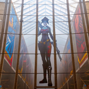 Widowmaker from Overwatch, standing tall, against a bright, colorful comic-con backdrop