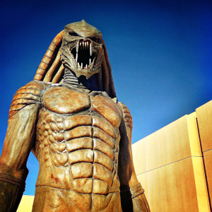 Alien from Prometheus. Aggressive pose, open mouth, sharp teeth, detailed textures, segmented skin. Against a minimalist black backdrop