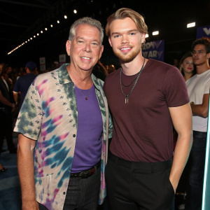 Elvis Duran and Chord Overstreet at the 2022 MTV Video Music Awards. Elvis, middle-aged, Caucasian, friendly face, tie-dye shirt, dark pants. Chord, Caucasian, friendly face, marled t-shirt.
