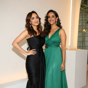 Neha Sharma and Aisha Sharma attending a book launch event. Both in elegant attire, against a minimalist backdrop.