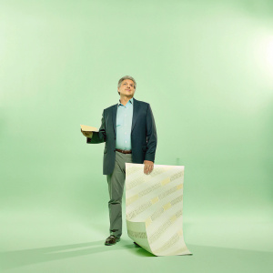 Sean Hannity, in a tailored dark suit and light blue shirt, stands at the Sundance Film Festival. Behind him, a vibrant yellow backdrop with the Sundance logo.