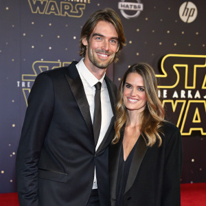 Camille Lacourt and Alice Detollenaere attending the Star Wars premiere. Red carpet event, smiling, dressed in formal attire, Star Wars themed backdrop.