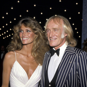 Ann Turkel and Richard Harris at a glamorous Hollywood premiere. Ann in a stunning white gown, Richard in a black and white striped tuxedo. They share a warm smile against a dark, starlit backdrop.