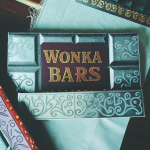 Promotional display for Wonka Bars. Dark brown colors, playful font, chocolate design with gold accents. Layered materials adding depth. Neutral background. Inspired by 'Willy Wonka and the Chocolate Factory'.