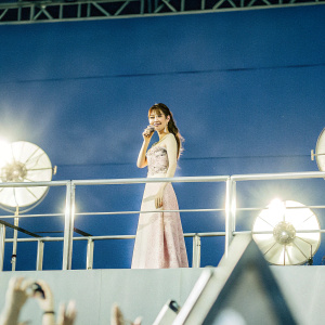 Dilraba Dilmurat, Chinese actress, at an award ceremony. Wearing a pink dress with intricate details. Confident pose. Background features flashing lights and fans.