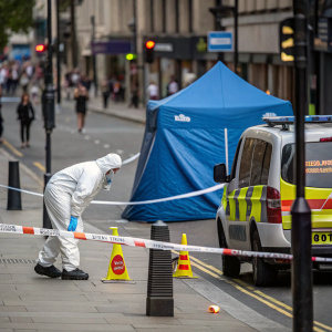 Forensic worker in white hazmat suit at crime scene investigation. Urban street, police barricades, caution tape, police vehicle. Orange and green labels, blue tent-like structure