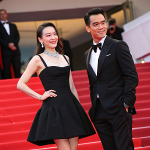 Shu Qi and Eddie Peng at Cannes Film Festival. Shu Qi in a black mini dress, Eddie Peng in a black tuxedo. Red carpet event