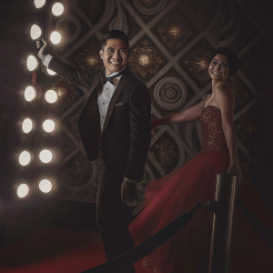 Mario Lopez and Gia Francesca Lopez at a glamorous award show. Red carpet event, dark backdrop with intricate gold patterns