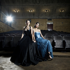 Jessica Henwick and Pearlyn Goh Kun Shan at EE BAFTA Film Awards 2023. Jessica in black gown, Pearlyn in blue dress. Decorated venue with BAFTA insignia