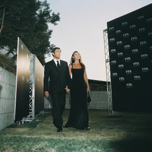 Javier Zanetti and Paula Zanetti, dressed in formal attire, at the FIFA Football Awards ceremony. Dark backdrop with FIFA logo