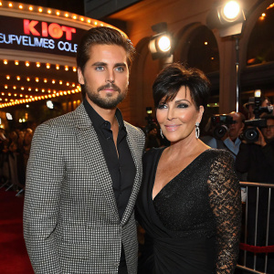 Scott Disick and Kris Jenner at the star-studded premiere. Flashing lights and crowd visible in background.