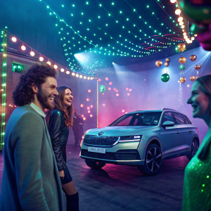 Digital ad for Skoda NejMix. Bright and lively scene with multiple people in a festive setting, surrounded by colorful lights and decorations.