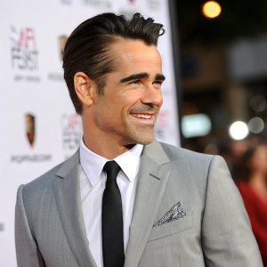 Colin Farrell at the premiere event,身穿灰色西装，系着黑色领带，面带微笑，背景是模糊的白色和标志，高分辨率照片。