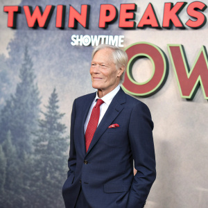 Richard Chamberlain at the 'Twin Peaks' Showtime event. He is wearing a dark blue suit and red tie. The background showcases a large, illuminated 'SHOWTIME' logo.