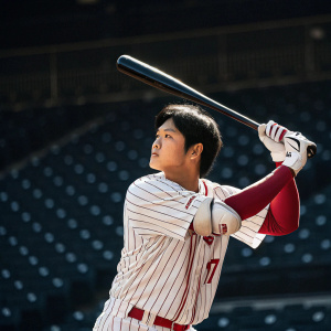Shohei Ohtani, baseball player, intense pose in batting stance. White jersey with red stripes. Background: empty stadium