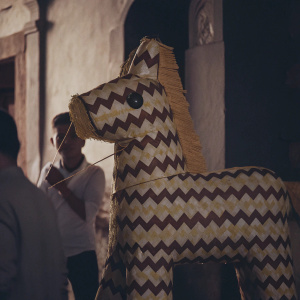 A vibrant, traditional Mexican piñata, shaped like a horse, adorned with chevron pattern in brown and yellow hues. Perfect for a festive celebration.