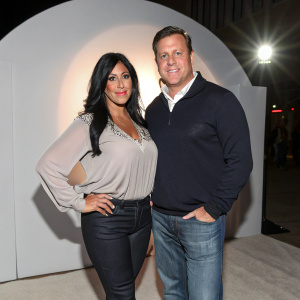 Angela 'Big Ang' Raiola and Neil Murphy in casual outfits, posing at an exclusive gala event. Minimalist backdrop, spotlight on their attire.