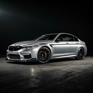 A high-definition 3D render of a BMW M5 Competition F90 in sleek silver with black wheels. Dramatic lighting on dark background highlights car details.