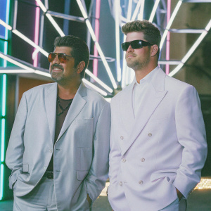 George Lopez and Robin Thicke at Hard Rock Cafe Hollywood opening. Gray suit, sunglasses, neon-lit background
