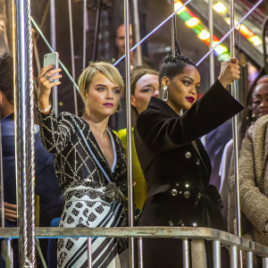 Cara Delevingne and Rihanna at the Met Gala. Cara in a black and white sequined gown, Rihanna in a black velvet blazer. Crowded backdrop
