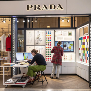 Prada logo and design elements showcased in a sleek, modern advertising campaign. Creatives at work in a vibrant studio environment.