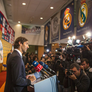 Raul Gonzalez, former soccer star, giving a press conference. Crowded room with logos and banners
