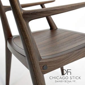 Close-up view of a sleek modern chair, the Chicago Stick Chair, by Danny Rosa for Studio 6f. The chair's handlebar made of dark wood with smooth, polished surface and visible wood grain.