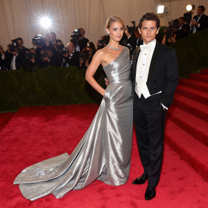 Claire Danes and Hugh Dancy attend the Met Gala. Claire in a dramatic floor-length silver gown, Hugh in a classic tuxedo. Red carpet ambiance.