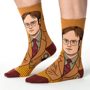 Illustrated socks featuring Dwight Schrute from The Office. Close-up design with flat style, highlighting his face and attire in vibrant brown hues. Fits adult sizes.